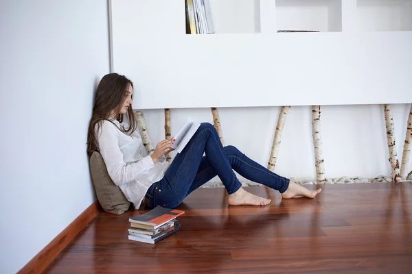 Расслабленная молодая женщина дома читает — стоковое фото