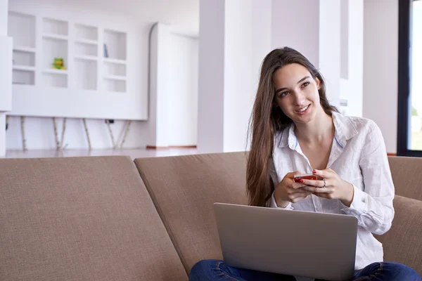 Relaxado jovem em casa trabalhando no computador portátil — Fotografia de Stock