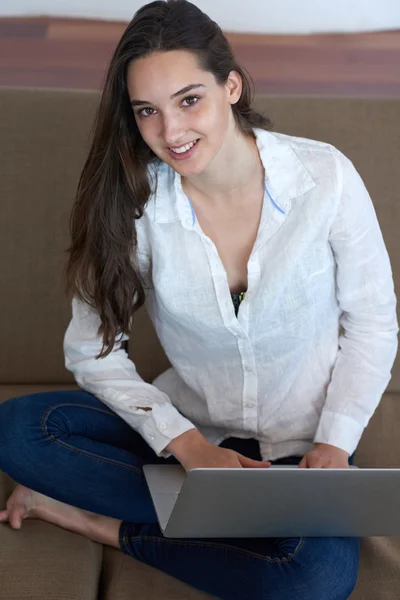 Relajada joven mujer en casa trabajando en el ordenador portátil —  Fotos de Stock