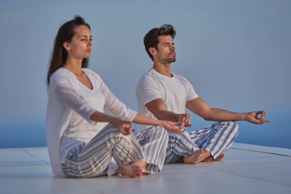 Ungt par som utövar yoga — Stockfoto