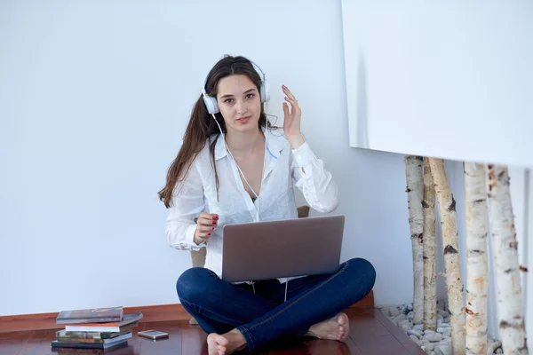 Jeune femme détendue à la maison travaillant sur un ordinateur portable — Photo