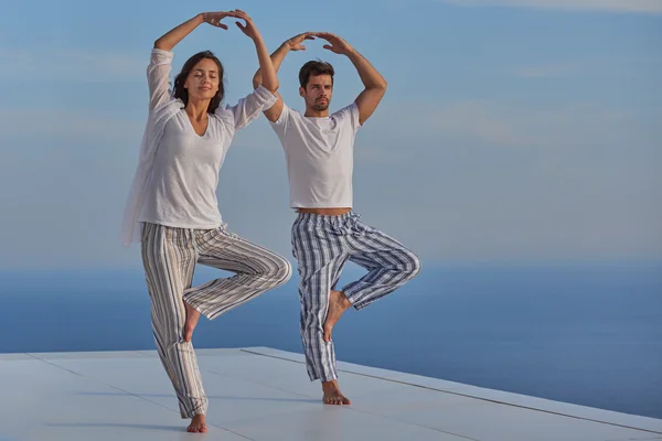 Young couple practicing yoga — Stock Photo, Image