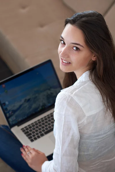 Ontspannen jonge vrouw thuis werken op laptopcomputer — Stockfoto