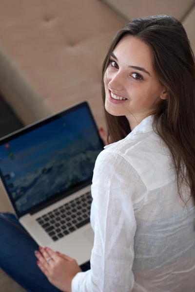 Relaxed young woman at home working on laptop computer — Stock Photo, Image