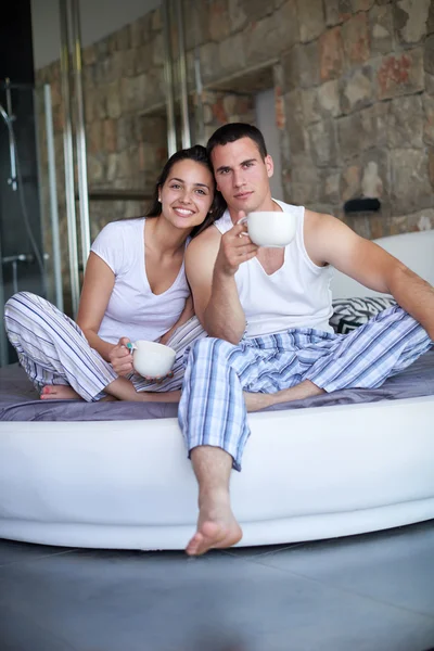 Glückliches junges Paar entspannt im Bett — Stockfoto