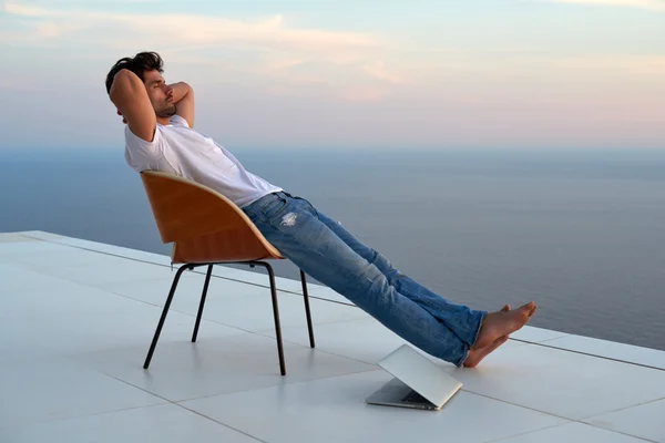 Relaxed young man at home on balcony — Stock Photo, Image