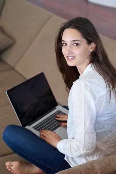 Ontspannen jonge vrouw thuis werken op laptopcomputer — Stockfoto