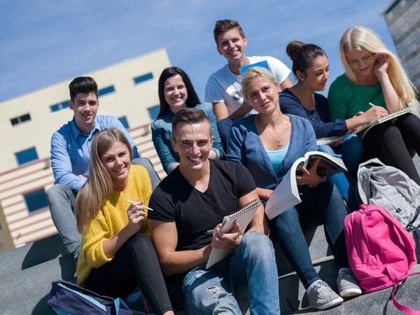 Studenti fuori seduti su gradini — Foto Stock