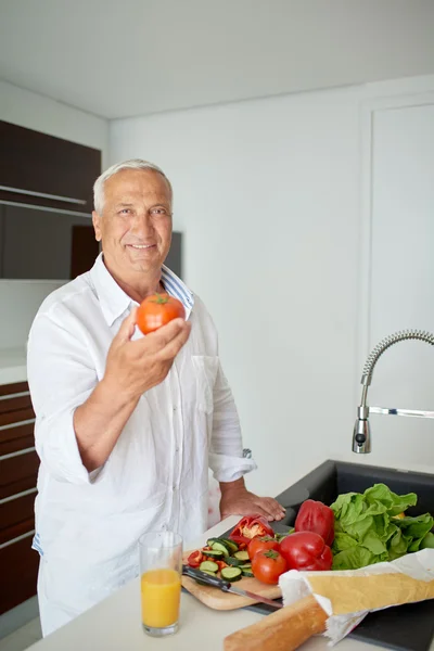 Mann kocht zu Hause und bereitet Salat in Küche zu — Stockfoto