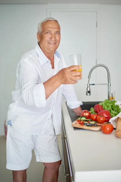 Man cooking at home preparing salad in kitchen — Stock Photo, Image