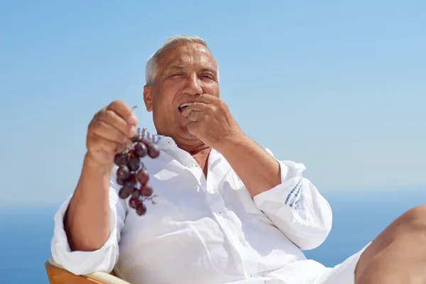 Senior man sitting outside — Stock Photo, Image