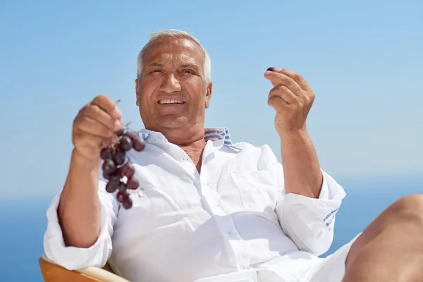 Senior man sitting outside — Stock Photo, Image