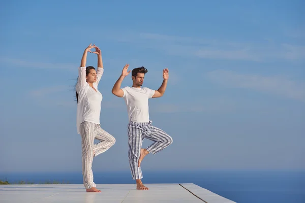 Young couple practicing yoga — Stock Photo, Image