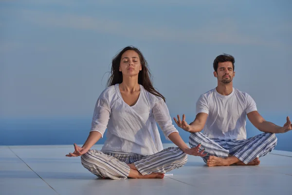 Jeune couple pratiquant le yoga — Photo