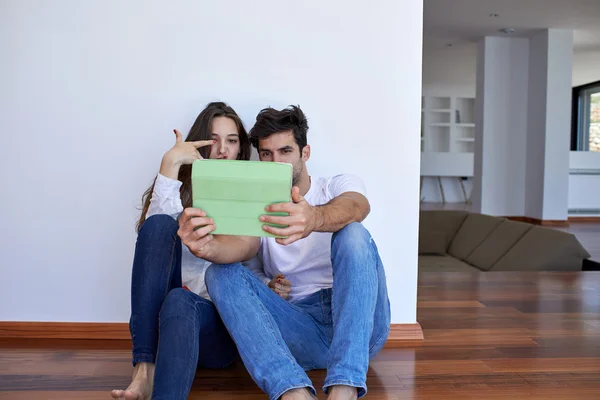 Casal em casa moderna usando computador tablet — Fotografia de Stock