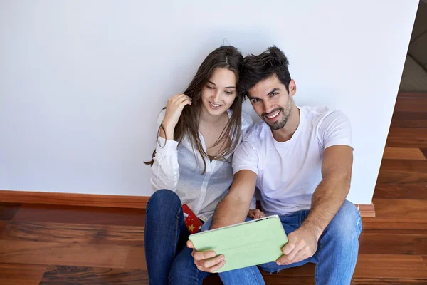 Casal em casa moderna usando computador tablet — Fotografia de Stock