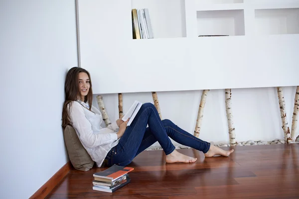 Relajada joven en casa leyendo — Foto de Stock