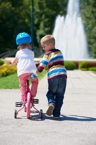 Ragazzo e ragazza nel parco imparare ad andare in bicicletta — Foto Stock