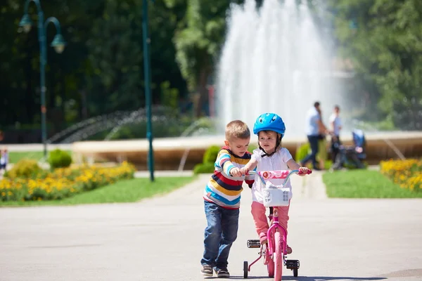 Мальчик и девочка в парке учатся кататься на велосипеде — стоковое фото