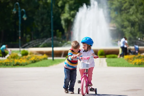 Garçon et fille dans le parc apprendre à faire du vélo — Photo