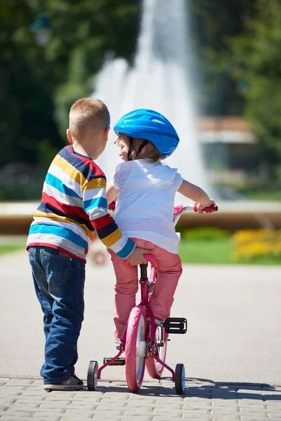 Garçon et fille dans le parc apprendre à faire du vélo — Photo