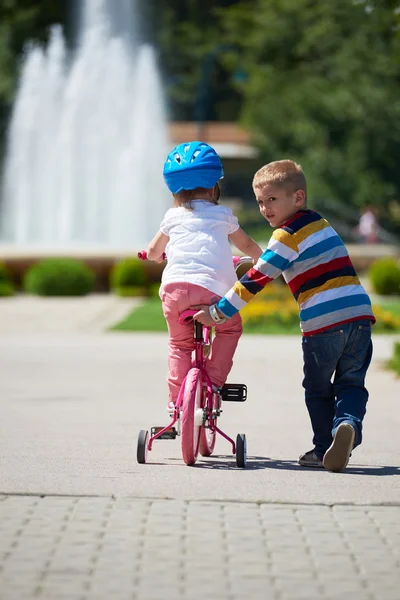 Jongen en meisje in het park leren om een fietstocht — Stockfoto