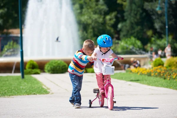 Ragazzo e ragazza nel parco imparare ad andare in bicicletta — Foto Stock