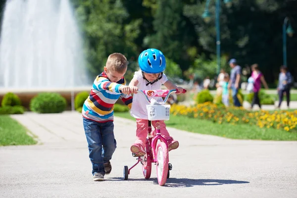 Ragazzo e ragazza nel parco imparare ad andare in bicicletta — Foto Stock