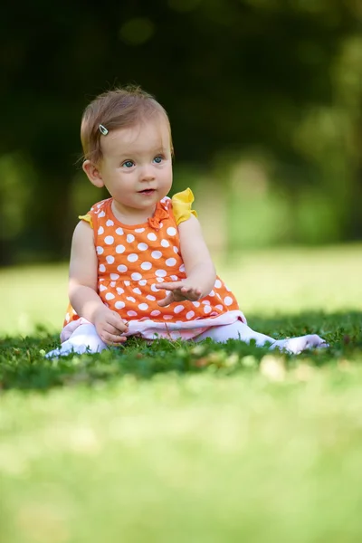 Baby sitzt auf Gras — Stockfoto