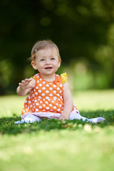 Baby sitzt auf Gras — Stockfoto