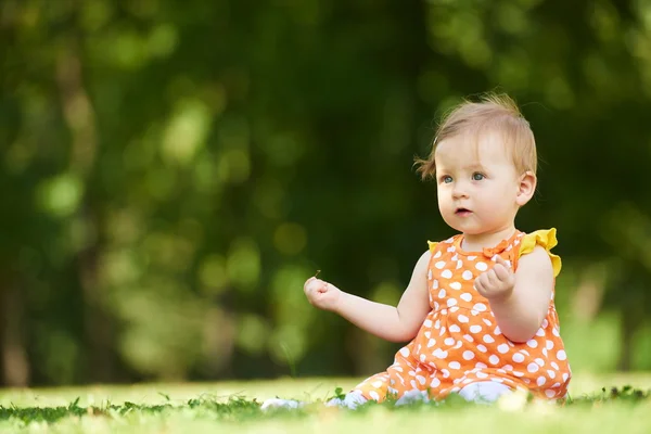 Çimenlerin üzerinde oturan bebek çocuk — Stok fotoğraf
