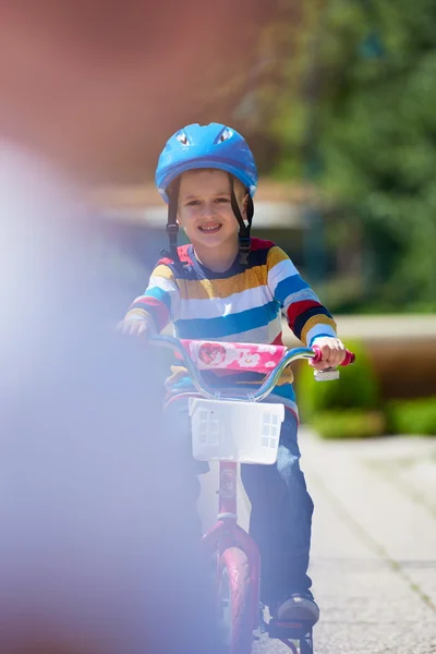 Счастливый мальчик учится ездить на своем первом велосипеде — стоковое фото
