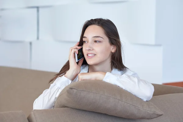 Mujer joven usando el teléfono celular en casa — Foto de Stock