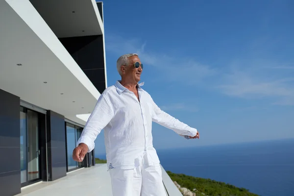 Uomo anziano di fronte alla casa moderna — Foto Stock