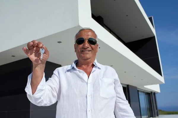 Hombre mayor frente a la casa moderna —  Fotos de Stock