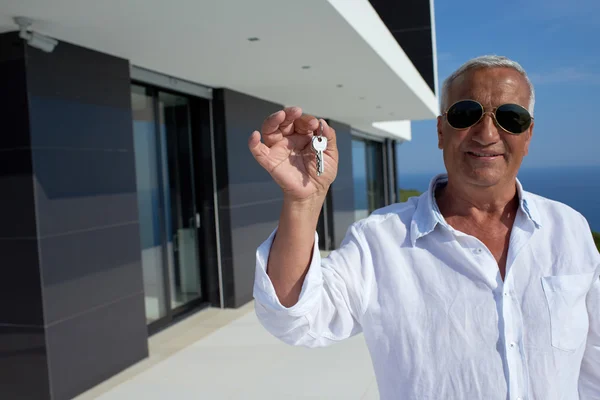 Homem sênior na frente da casa moderna — Fotografia de Stock