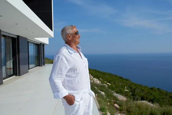 Uomo anziano di fronte alla casa moderna — Foto Stock