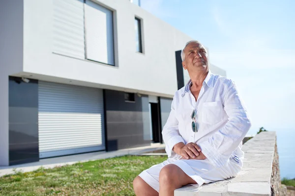 Uomo anziano di fronte alla casa moderna — Foto Stock