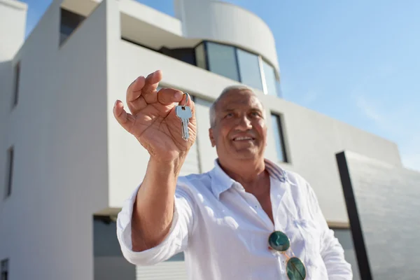 Senior man in front of modern home — Stock Photo, Image