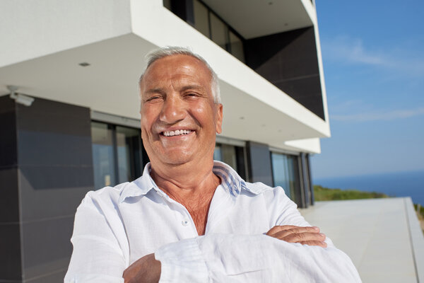 senior man in front of modern home