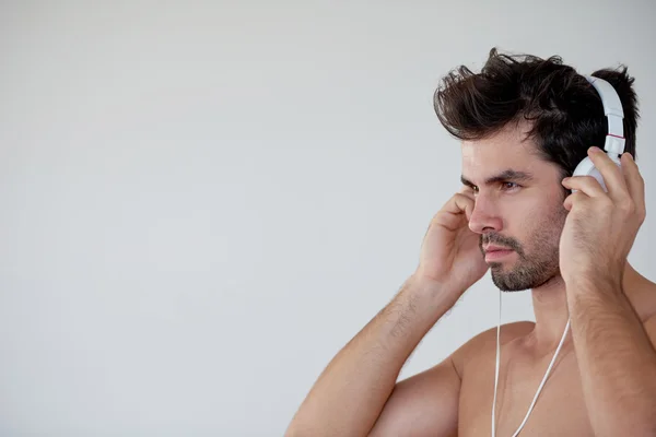 Knappe jonge man luisteren muziek op koptelefoon — Stockfoto