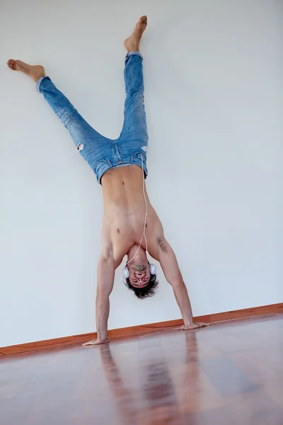 Joven guapo escuchando música en los auriculares —  Fotos de Stock