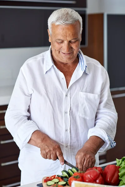 Senior man thuis koken — Stockfoto