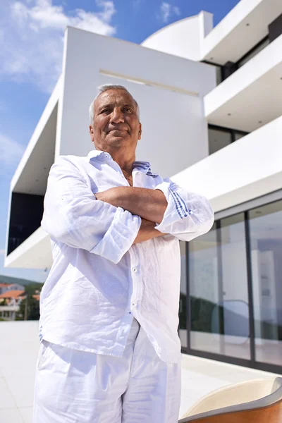 Hombre mayor frente a la casa moderna —  Fotos de Stock