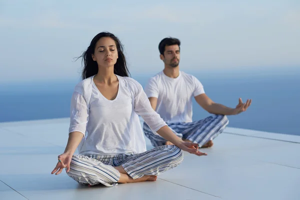 Jeune couple pratiquant le yoga — Photo