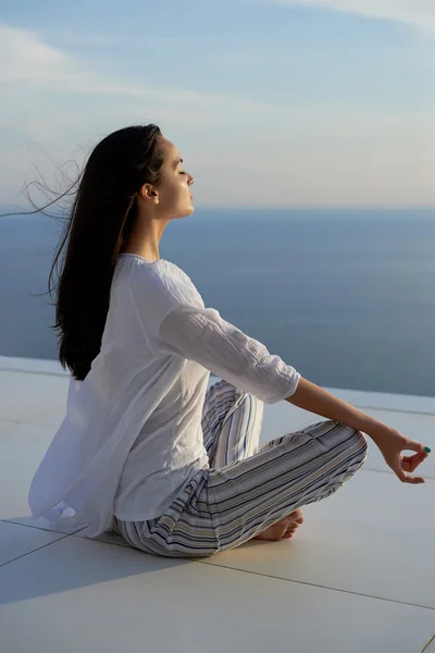 Ung kvinde udøver yoga - Stock-foto