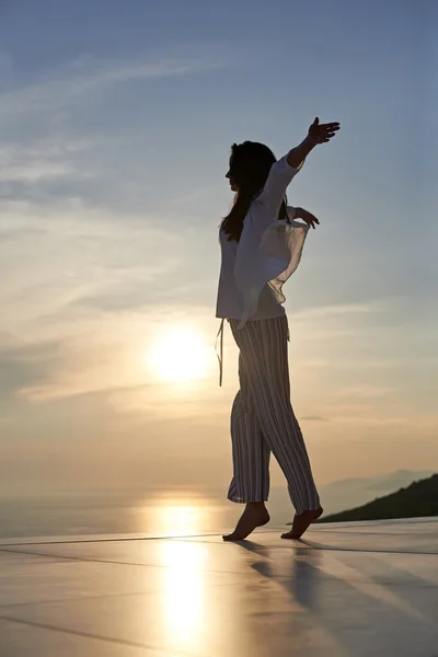 Jonge vrouw genieten van zonsondergang — Stockfoto