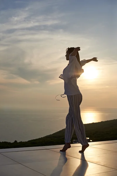 Jovem mulher desfrutando do pôr do sol — Fotografia de Stock