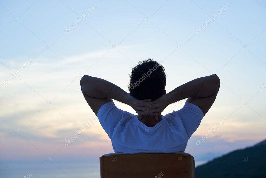 relaxed young man at home on balcony