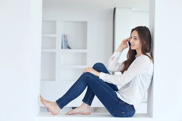 Mladá žena doma používat mobilní telefon — Stock fotografie